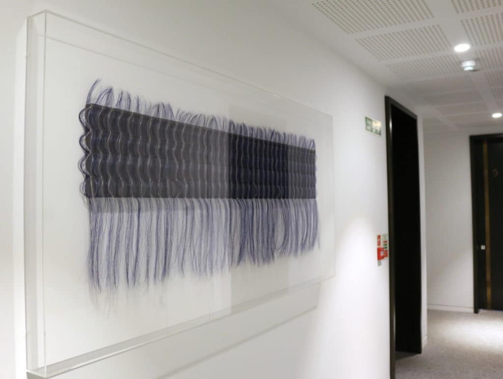 blue art piece in white hallway